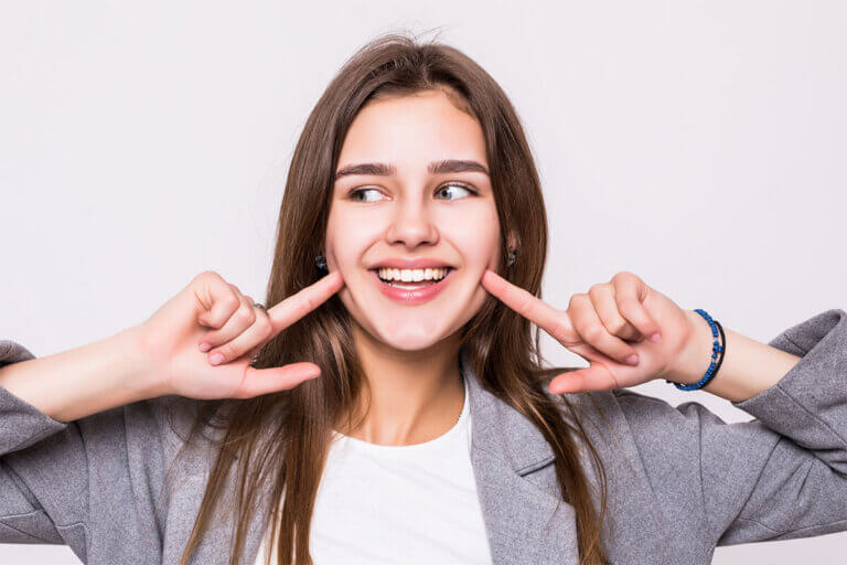 Virtual dental consultation - young woman pointing at her smile